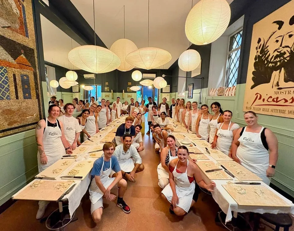 Group of guests around a long table during a cooking class in Rome