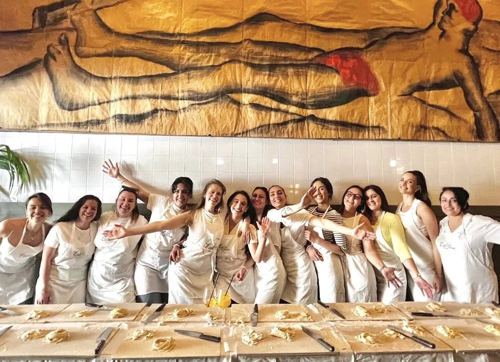 Guests waving during a group cooking class in Rome